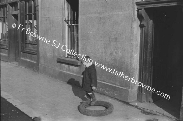 CHILD PLAYING WITH TYRE